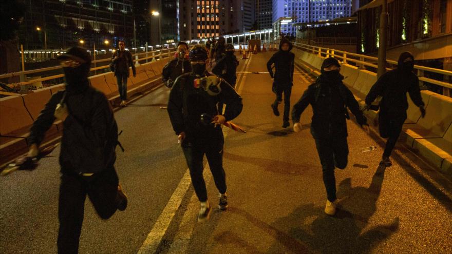 Varios manifestantes huyen de la Policía durante las protestas en Hong Kong, 8 de diciembre de 2019. (Foto: AFP)