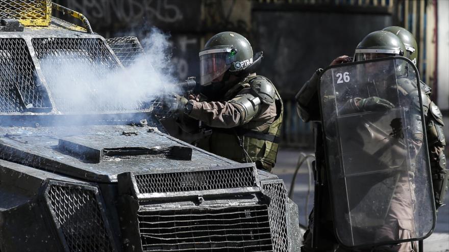 Un agente de la Policía chilena dispara contra los manifestantes, Santiago (capital), 14 de noviembre de 2019. (Foto: AFP)