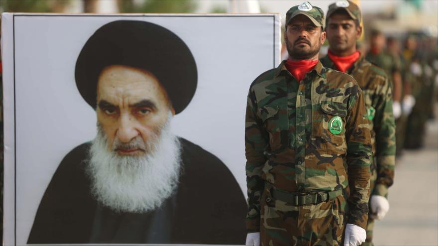 Militares frente a una imagen del máximo clérigo chií de Irak, el gran ayatolá Seyed Ali Sistani, agosto de 2019. (Foto: AFP)