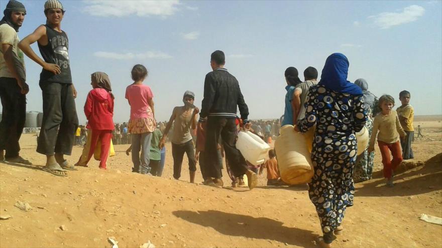  Refugiados sirios en busca de agua potable en el campamento de Al-Rukban, en la provincia de Al-Hasaka, 23 de junio de 2016. (Foto: AP)