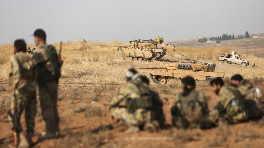 Combatientes armados respaldados por Turquía se reúnen cerca de tanques turcos en Ras Al-Ain, Al-Hasaka (noreste), 28 de octubre de 2019. (Foto: AFP)