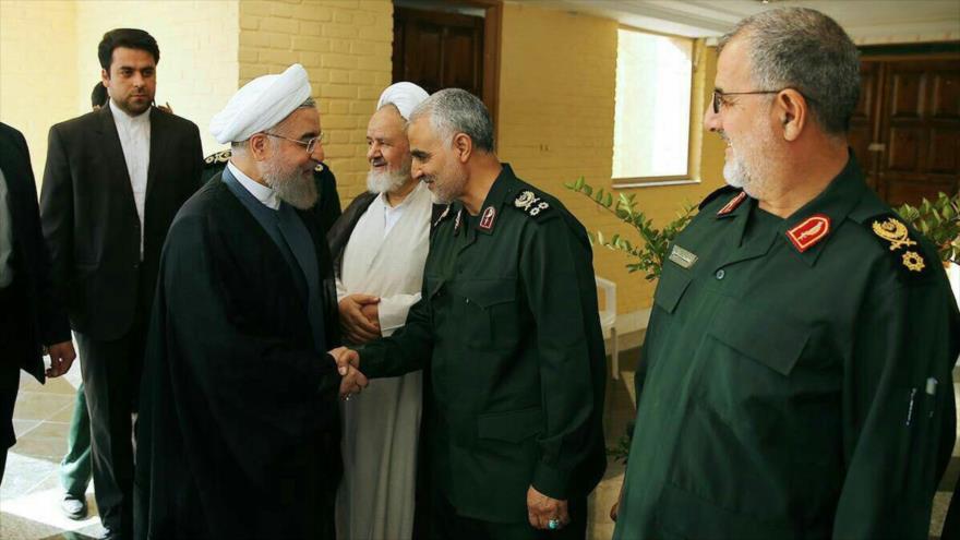 El presidente de Irán, Hasan Rohani, (2.º a izq.) da la mano al comandante de la Fuerza de Quds del CGRI de Irán, el teniente general Qasem Soleimani.