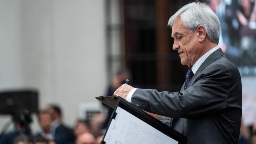 El presidente de Chile, Sebastián Piñera, firma un documento en el palacio de La Moneda en Santiago, la capital, 23 de diciembre de 2019. (Foto: AFP)