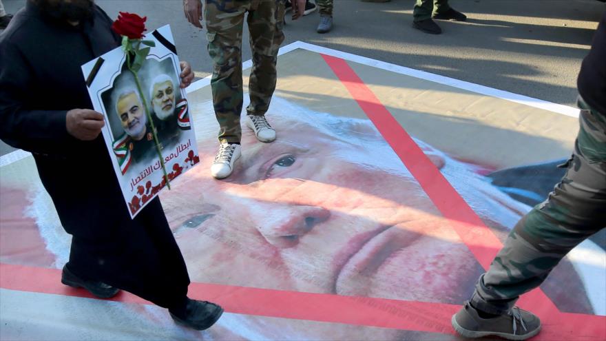 Iraquíes pisan un retrato de Donald Trump en una protesta hecha por asesinato de dos altos comandantes de Irán e Irak, 6 de enero de 2020. (Foto: AFP)