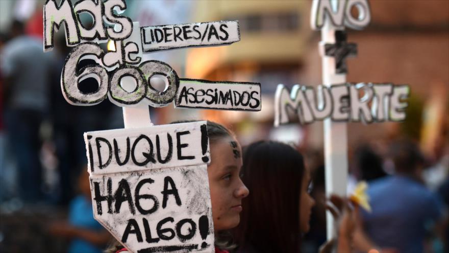 Una mujer sostiene un cartel en una protesta contra el asesinato de líderes sociales en la ciudad de Cali, suroeste de Colombia, 26 de julio de 2019. (Foto: AFP)