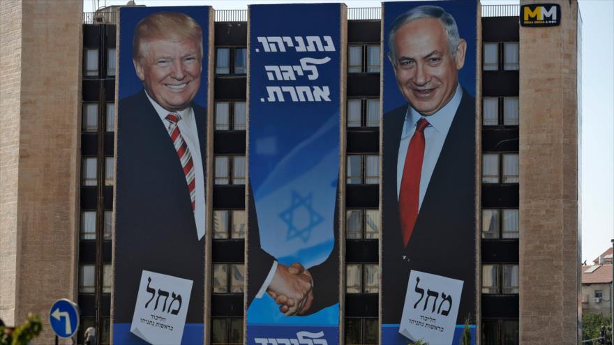 Un gran valla publicitaria muestra al presidente de EE.UU., Donald Trump, y al primer ministro israelí, Benjamín Netanyahu, dándose la mano.