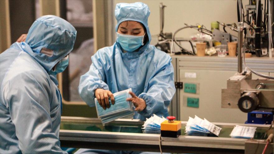 Trabajadores producen máscaras faciales en una fábrica en Yangzhou, en la provincia oriental china de Jiangsu, 26 de enero de 2020. (Foto: AFP)