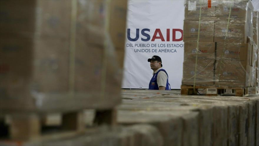 Un miembro de la Agencia de Estados Unidos para el Desarrollo Internacional (USAID) entre cajas acopiadas en Colombia de la “ayuda humanitaria” destinada a Venezuela.