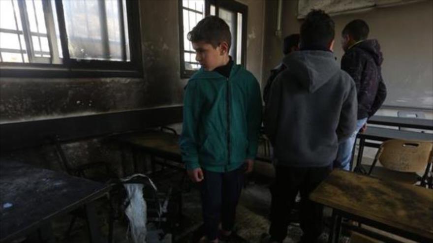 Niños palestinos inspeccionan los daños causados por un incendio provocado por los israelíes en Naplusa, Cisjordania, 28 de enero de 2020.