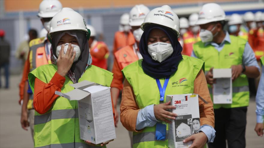 Funcionarios de salud indonesios distribuyen máscaras faciales en el puerto de Panjang en Lampung, Indonesia, 29 de enero de 2020. (Foto: AFP)