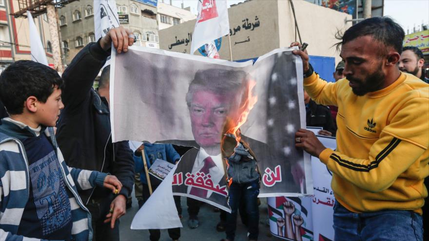 Los palestinos queman un cartel del presidente de EE.UU., Donald Trump, en una protesta en Gaza, 1 de febrero de 2020. (Foto: AFP)