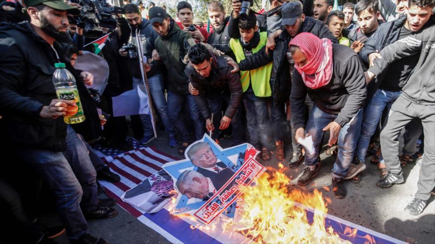 Manifestantes palestinos queman retratos del presidente estadounidense, Donald Trump, y del premier israelí, Benjamín Netanyahu, 31 de enero de 2020. (Foto: AFP)