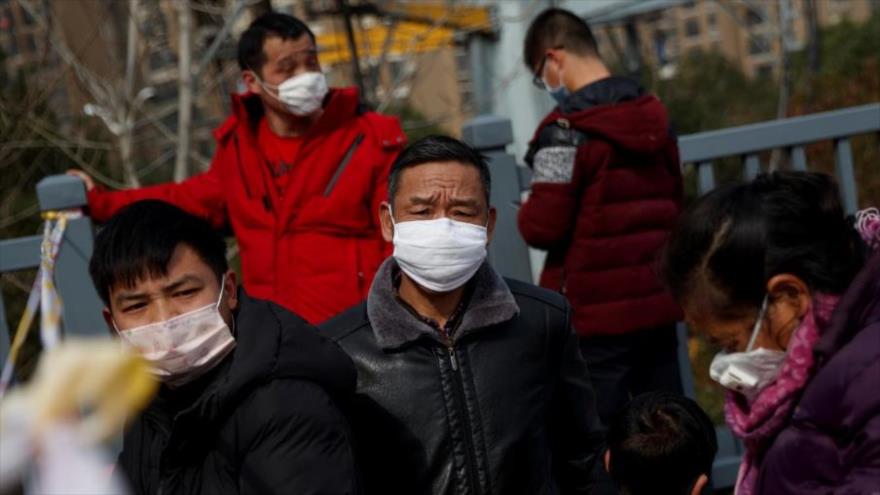 Varios ciudadanos chinos llevan máscaras para evitar contagiarse con el coronavirus 2019-nCoV.