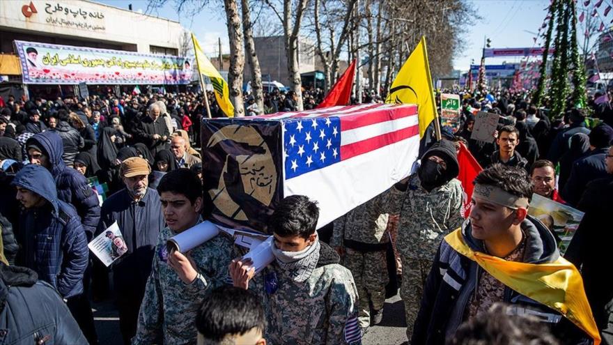 Iraníes portando simbólicamente un ataúd de la muerte política de EE.UU. piden su salida de la zona durante el aniversario de la Revolución, 11 de febrero de 2020.