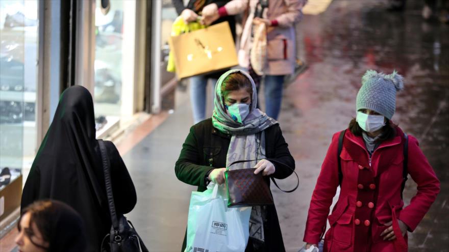 Mujeres iraníes con mascarillas de protección caminan en una calle en Teherán (capital), 20 de febrero de 2020. (Foto: AFP)