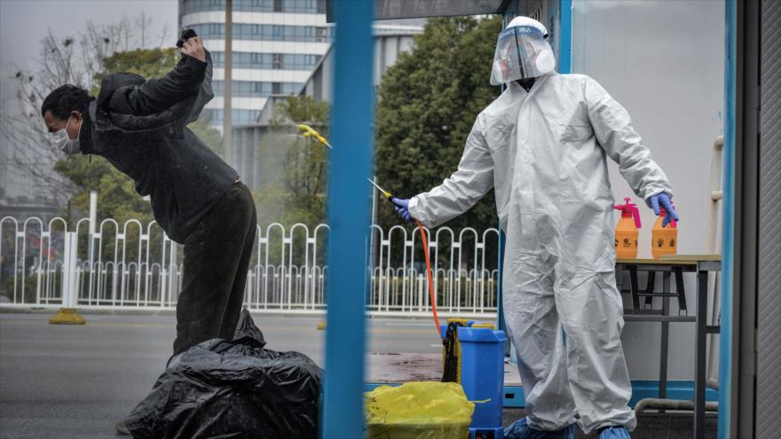 La foto muestra cómo las autoridades sanitarias de China desinfectan a un hombre recuperado de coronavirus, 22 de febrero de 2020. (Foto: AFP)