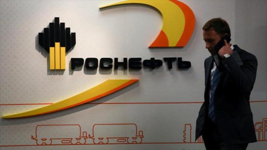 Un empleado de la empresa petrolera rusa Rosneft Trading pasa por delante del logotipo cooperativo de la compaña.