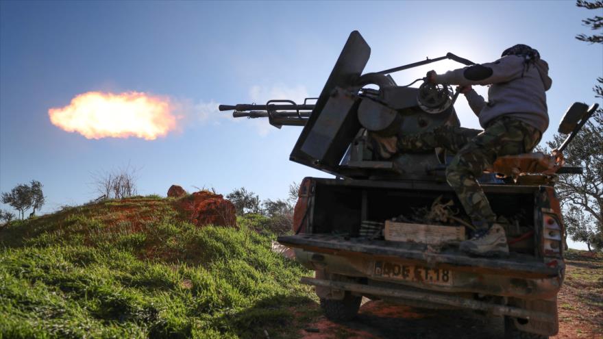 Un combatiente respaldado por Turquía dispara con una ametralladora pesada cerca de Idlib, noroeste de Siria, 26 de febrero de 2020. (Foto: AFP)