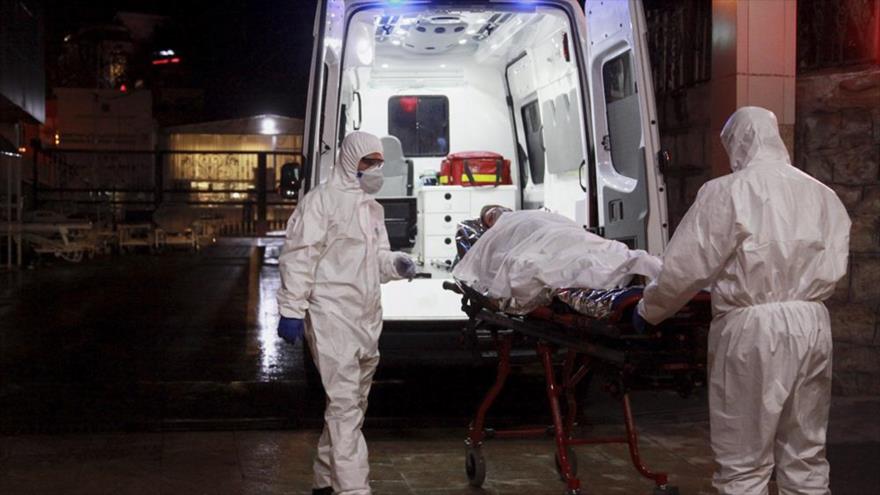 Agentes sanitarios trasladan a paciente afectado con coronavirus en un hospital en Teherán, 29 de febrero de 2020. (Foto: YJC)