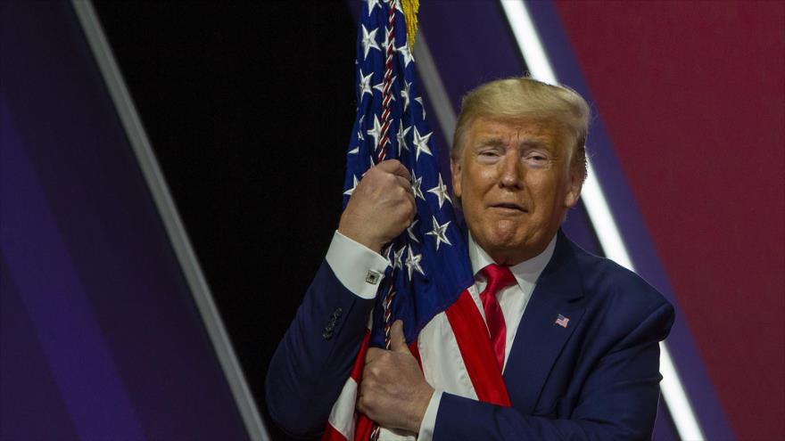 El presidente de EE.UU., Donald Trump, sostiene la bandera de su país, Maryland, 29 de febrero de 2020. (Foto: AFP)