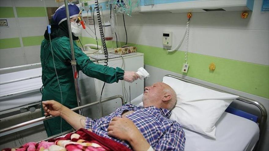 Una enfermera toma la temperatura a una persona contagiada por coronavirus en un hospital de la ciudad iraní de Qom, 1 de marzo de 2020. (Foto: Tasnim)