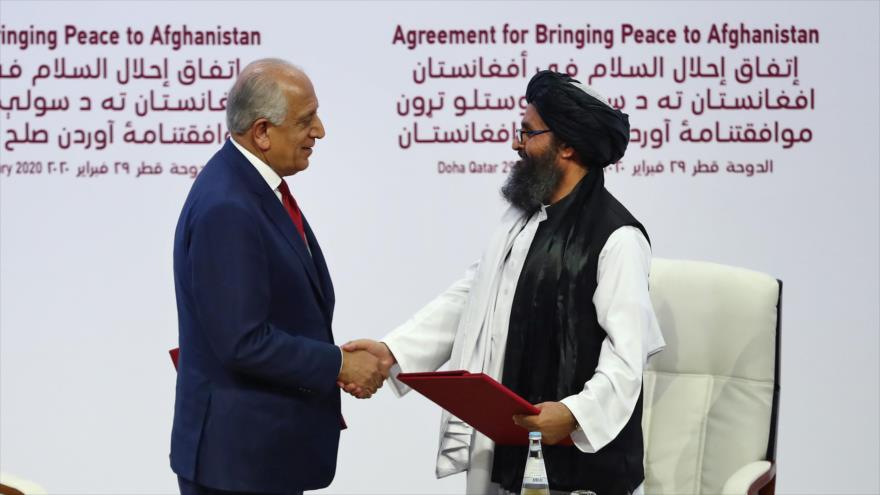 El representante especial de EE.UU., Zalmay Khalilzad, y Abdul Qani Baradar, jefe del buró político de Talibán, 29 de febrero de 2020. (Foto: AFP)