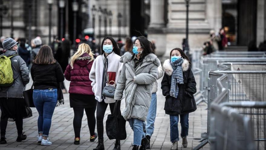 Los turistas en París, capital de Francia, usan mascarillas para protegerse contra el COVID-19.