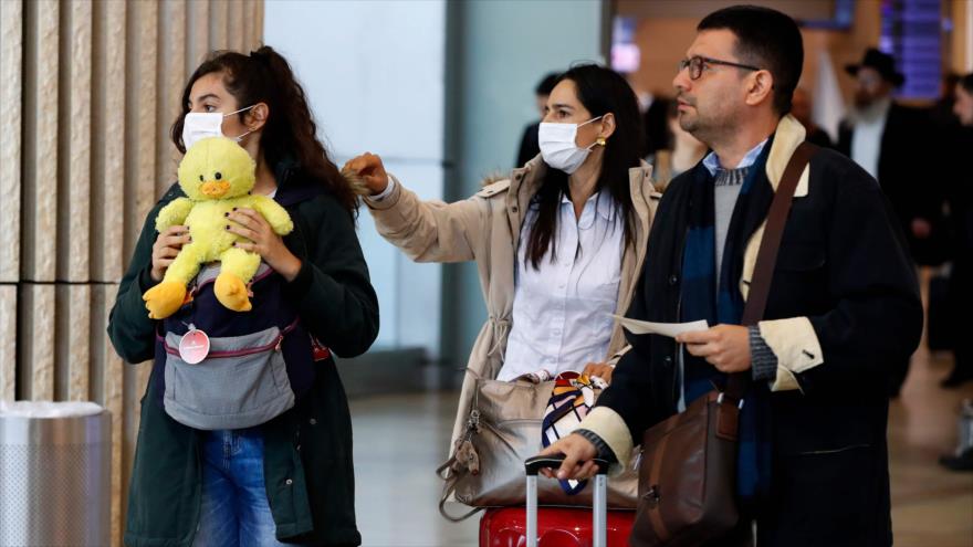 Pasajeros en el aeropuerto israelí Ben Gurión usan mascarilla por el coronavirus, 27 de febrero de 2020. (Foto: AFP)