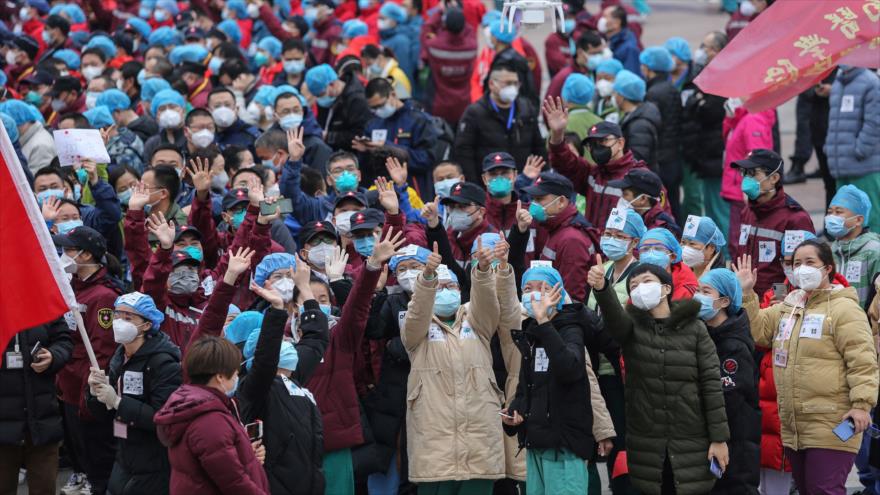 El personal médico celebra que todos los pacientes con coronavirus fueron dados de alta en un hospital temporal establecido en Wuhan, 9 de marzo de 2020. (Foto: AFP)