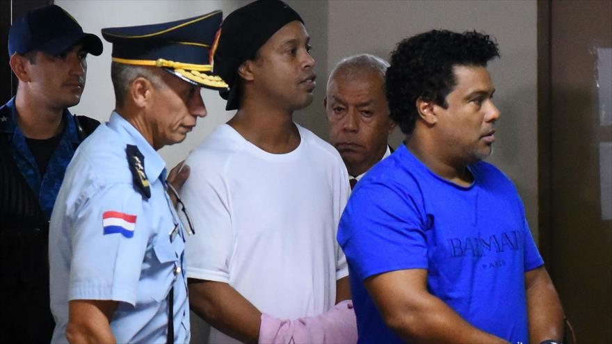 Exfutbolista brasileño Ronaldinho (c) y su hermano llegan al Palacio de Justicia en Paraguay para comparecer ante un fiscal, 7 de marzo de 2020. (Foto: AFP)