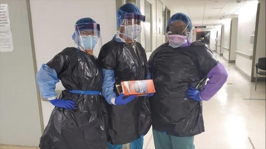 Enfermeros del Hospital Mount Sinai en Nueva York, llevando bolsa de basura por falta de batas de protección.