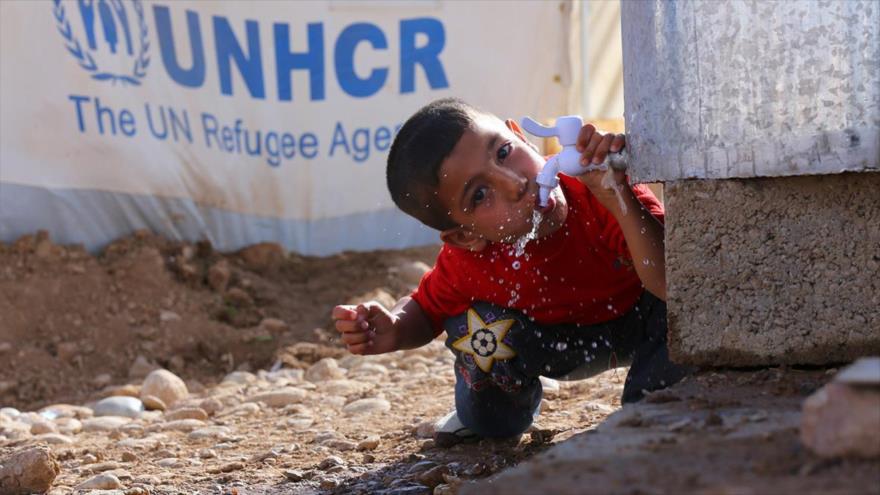 Un refugiado sirio bebe agua de un tanque en un campamento de Qushtapa, en las afueras de la ciudad de Arbil, en el Kurdistán iraquí. (Foto: Reuters)