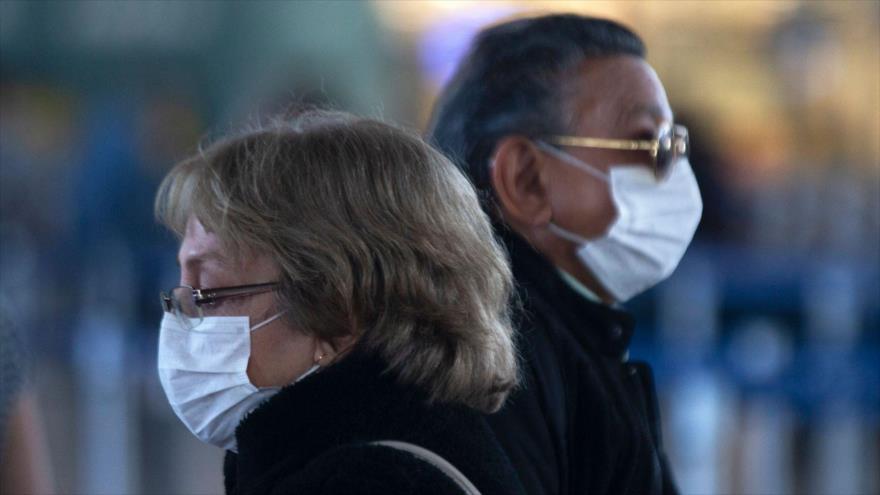 Los pasajeros usan mascarillas en el Aeropuerto Internacional Arturo Merino Benítez en Santiago (Chile), 14 de marzo de 2020. (Foto: AFP)