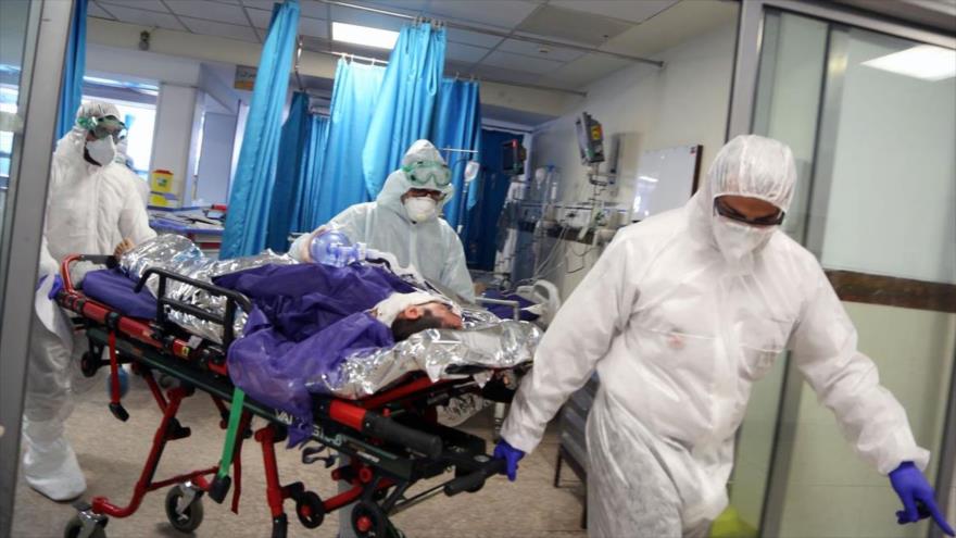 Personal de un hospital en Teherán, la capital iraní, traslada a un enfermo con el coronavirus.