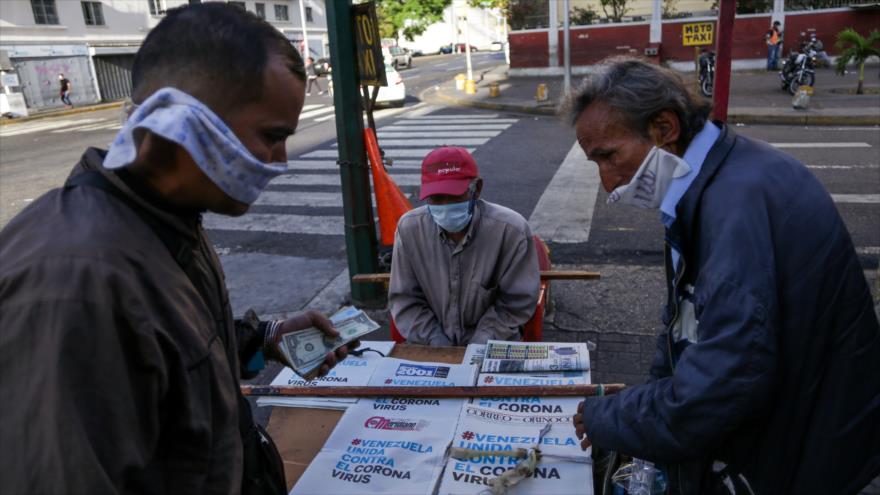 Hombres venezolanos llevan mascarillas en un quiosco en Caracas, la capital, 17 de marzo de 2020. (Foto: AFP)
