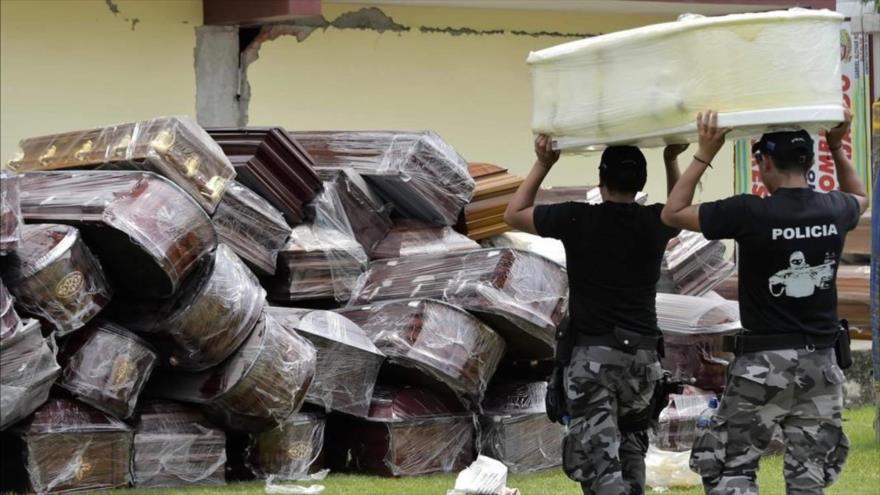 Agentes de policía apilan ataúdes en Pedernales, en Guayaquil, Ecuador, el April 7, 2020. (FOTO: AFP)