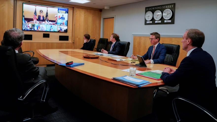 Trump habla en una reunión virtual del G7, mientras el canciller británico, Dominic Raab (dcha.), escucha, Londres, 16 de abril de 2020. (Foto: AFP)