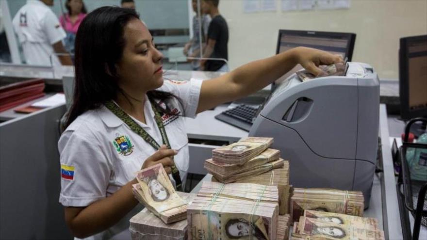 Una funcionaria del Banco Central de Venezuela (BCV) contabiliza unos fajos de billetes nacionales.