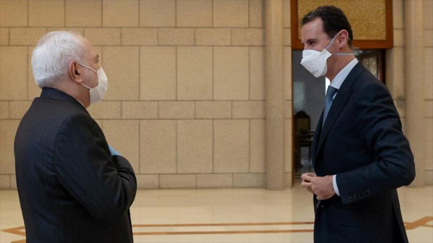 El canciller iraní, Mohamad Yavad Zarif (izda.) y el presidente de Siria, Bashar al-Asad, en Damasco, capital siria, 20 de abril de 2020.