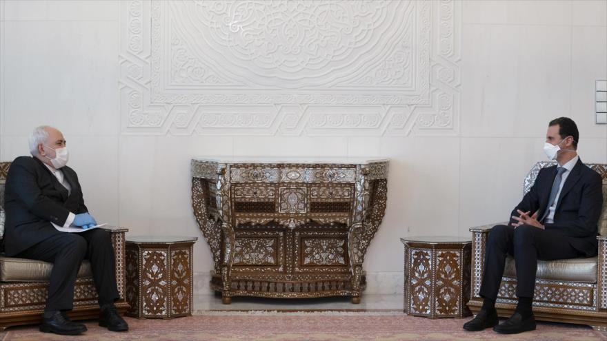 El presidente sirio, Bashar al-Asad (dcha.), en una reunión con el canciller iraní, Mohamad Yavad Zarif, Damasco, 20 de abril de 2020. (Foto: @Presidency_Sy)