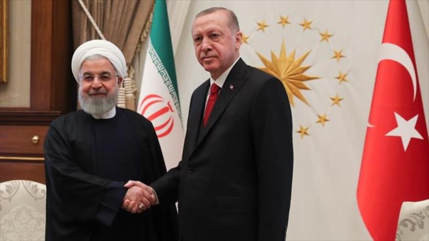 El presidente iraní, Hasan Rohani (izq.), saluda a su homólogo turco, Recep Tayyip Erdogan.