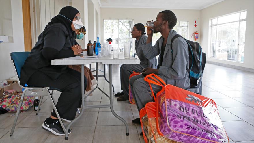 Una profesional de la salud visita a un hombre sin hogar en un centro de refugio en Pretoria, capital de Sudáfrica, 16 de abril de 2020. (Foto: AFP).