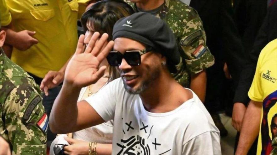El exjugador brasileño Ronaldinho saluda a sus hinchas mientras es conducido a prisión en Paraguay.