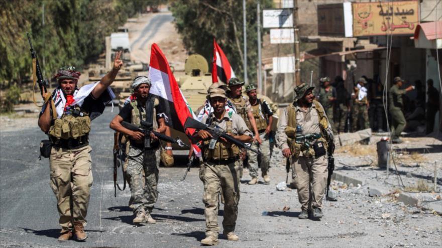 Combatientes de las Al-Hashad Al-Shabi avanzan por una calle en la ciudad de Tal Afar, al oeste de Mosul.
