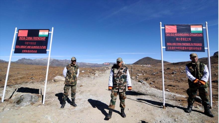 Fuerzas chinas hacen guardia cerca de una barrera fronteriza entre China y La India.