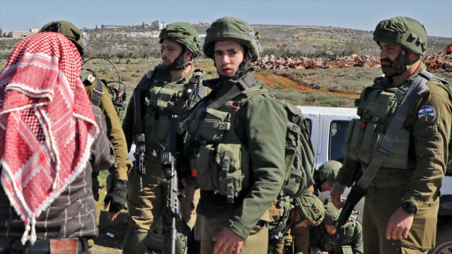 Un manifestante palestino habla con soldados israelíes, la aldea de Aqraba, sur de la ciudad cisjordana de Nablus, 3 de marzo de 2020. (Foto: AFP)