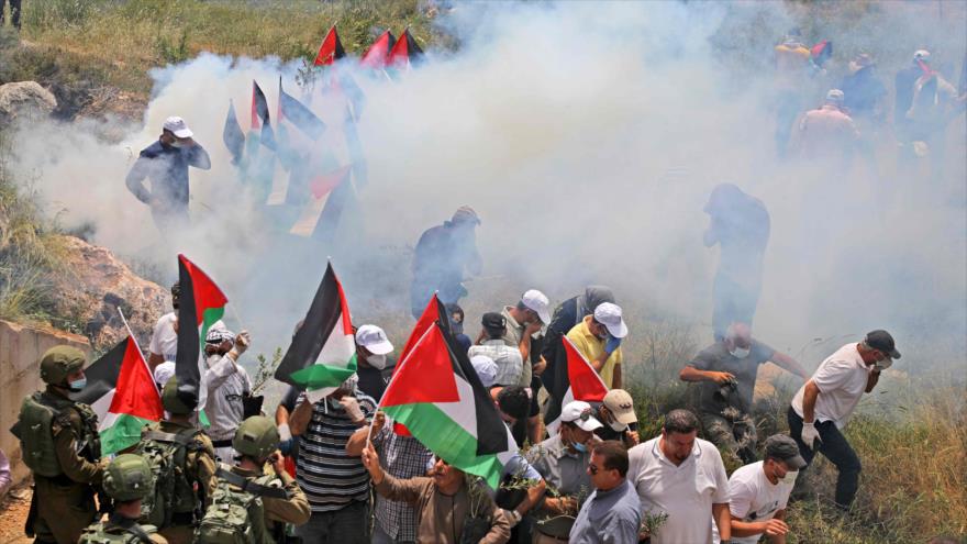Militares israelíes lanzan gases lacrimógenos contra manifestantes palestinos cerca del poblado de Al-Sawiya, en la ocupada Cisjordania, 15 de mayo de 2020.