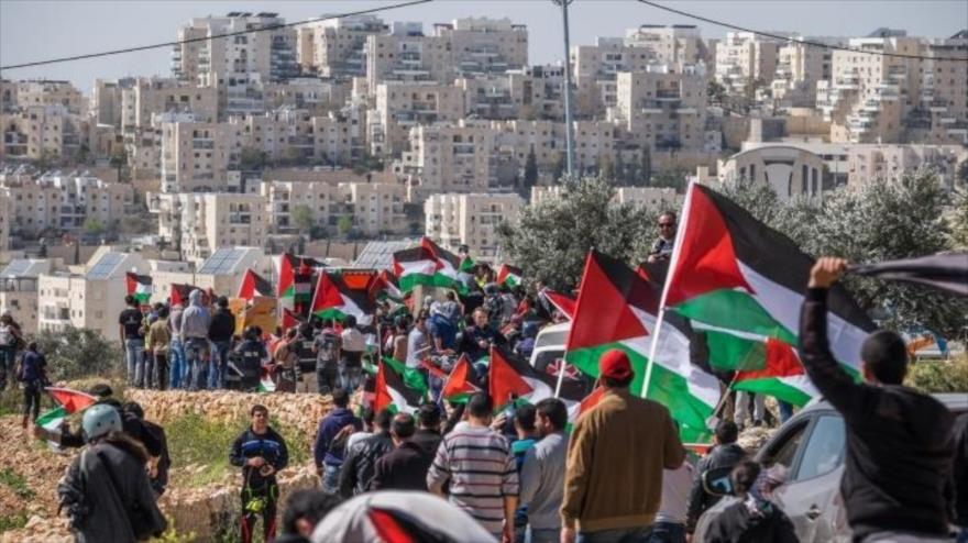 Un grupo de defensores de Palestina se congrega ante un asentamiento israelí en la ocupada Cisjordania.