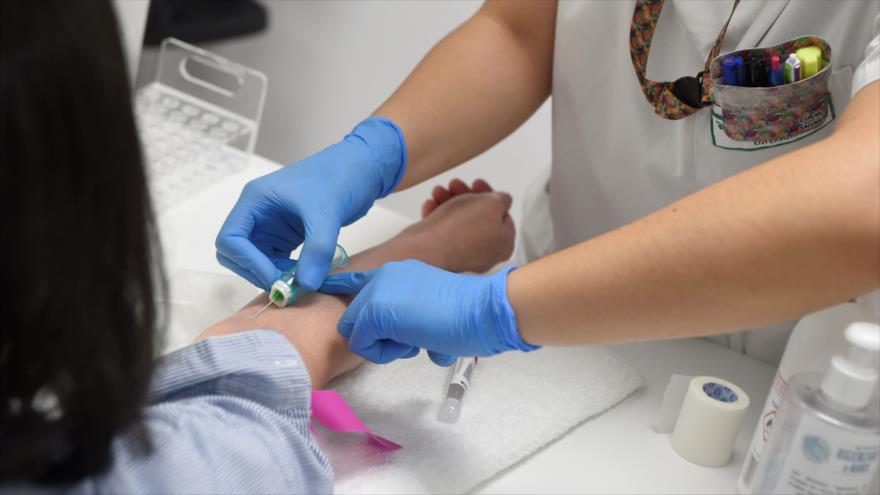 Un personal médico toma una muestra de sangre de una mujer para analizar la COVID-19 en Vigo, España, 14 de mayo de 2020. (Foto: AFP)