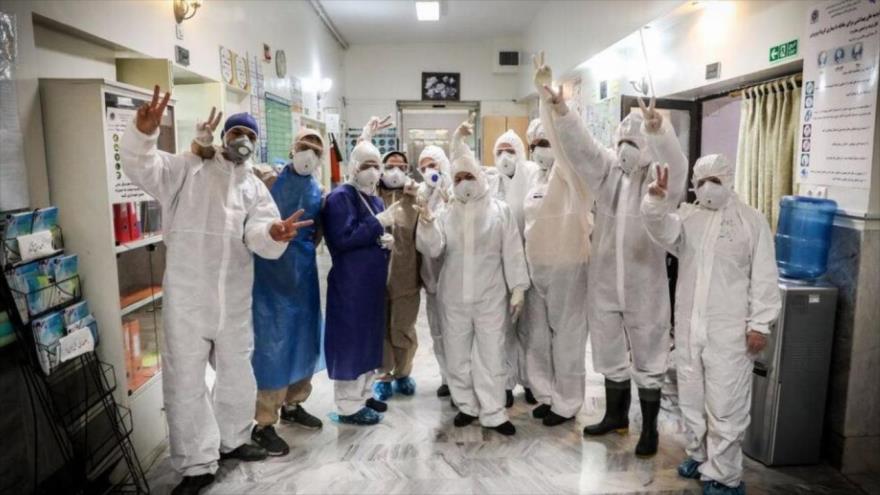 Personal médico en un hospital en Teherán, capital iraní, muestra signos de victoria con sus dedos en medio de su lucha contra la COVID-19.